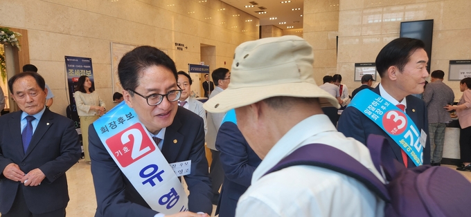 기호2번 유영조 한국세무사회장 후보가 한 세무사와 악수하며 한표를 부탁하고 있다. 