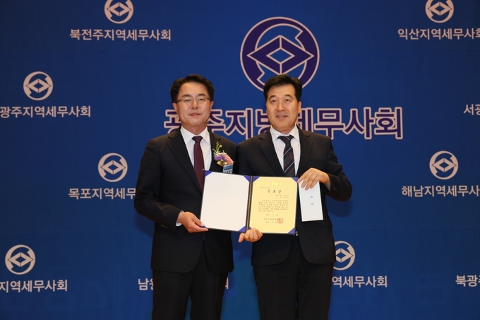 유권규 광주세무사회장이 윤정두 세무사<오른쪽>에게 공로상을 수여하고 있다.