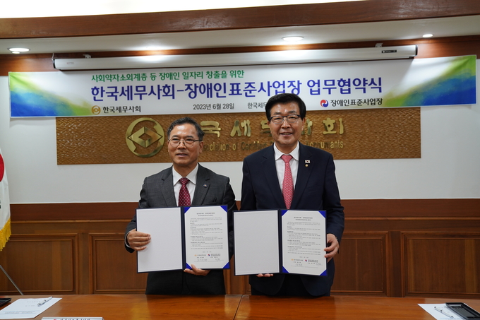 원경희 한국세무사회장(오른쪽)이 최봉실 장애인표준사업장 대표와 업무협약 체결 후 기념촬영하고 있다.