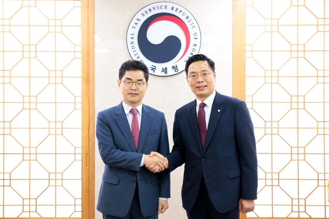 구재이<오른쪽> 한국세무사회장이 김창기 국세청장과 악수를 나누고 있다. 