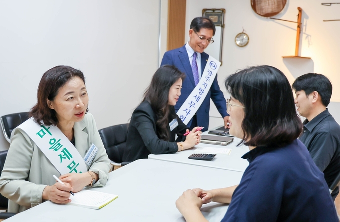 (왼쪽부터)김명하, 임태이 마을세무사가 상인들에게 세무상담을 해주고 있다.