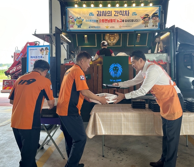  김인규 하이트진로 대표(오른쪽)가 지난 12일 완주소방서 소방공무원에게 간식을 직접 전달하고 있다.(사진=하이트진로)