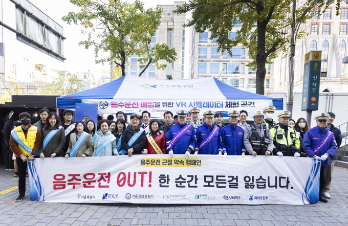오비맥주와 강남경찰서가 지난 7일 서울 신사역 부근에서 서울시, 강남구청, 도로교통공단, 한국교통안전공단, 하이트진로와 함께 음주운전 근절 캠페인을 펼치고 기념사진을 찍고 있다(사진=오비맥주).
