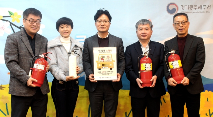 정경철 경기광주세무서장(가운데)이 각 과 과장들과 함께 ‘내 옆에 소화기’ 릴레이 챌린지에 동참하고 있다.