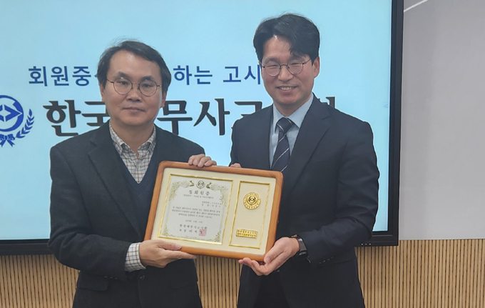 이석정 회장이 이강오<왼쪽> 세무사에게 세무사 전문분야포럼 정회원증을 전달하고 있다.