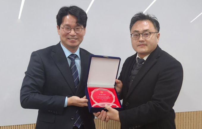 이석정 회장이 양도소득세 우수사례를 발표한 최왕규<오른쪽> 세무사에게 최우수상패를 전달하고 있다.