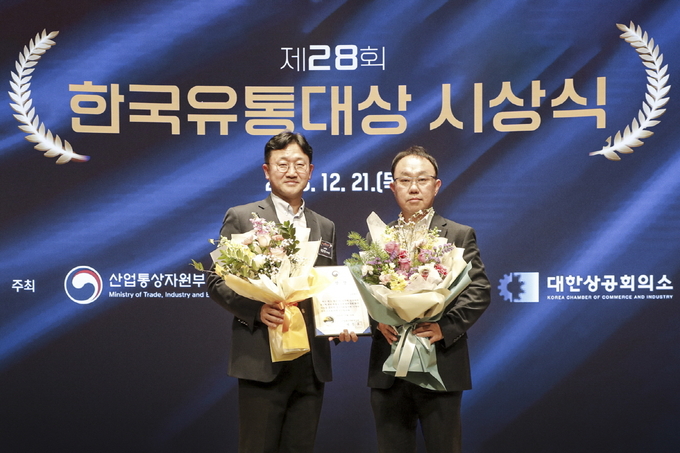 서울 중구 대한상공회의소에서 열린 한국유통대상 시상식에서 이근창(왼쪽) 오비맥주 가정채널 영업총괄 부사장, 이경호 북서수퍼지점장이 기념촬영을 하고 있다.