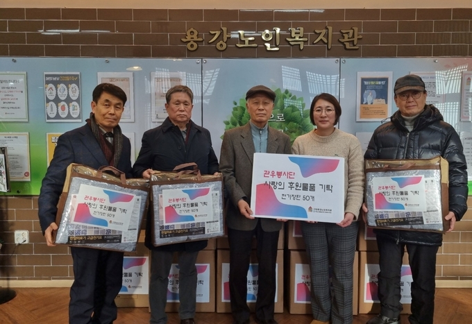 안치성 관우봉사단장<중앙>과 단원들이 갑진년 새해를 맞아 용강노인복지관을 찾아 전기장판을 전달하고 있다.