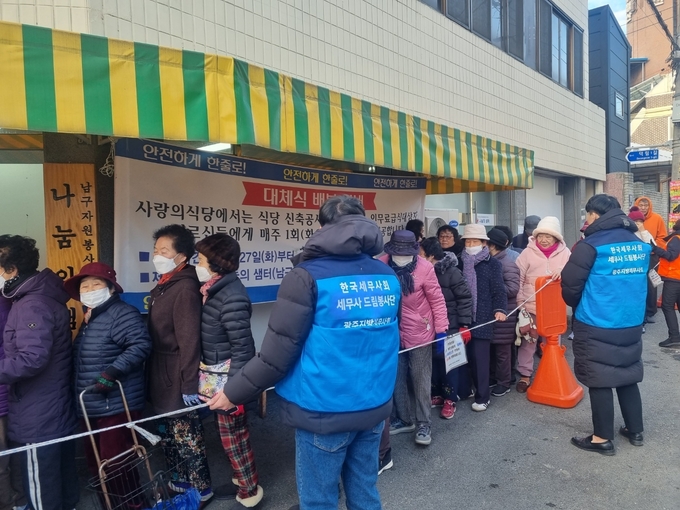 광주지방세무사회 소속 세무사들이 광주시 남구 나눔의 샘터에서 사랑의 식당 자원봉사자들과 함께 350여명의 결식 어르신들에게 도시락 을 전달하고 있다. 