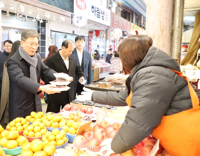 박수복 인천청장이 신기시장을 찾아 시장상인으로부터 과일을 구매하고 있다. 