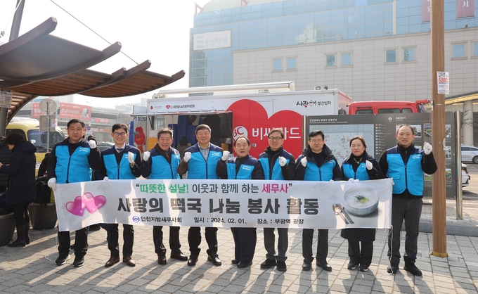 인천세무사회 임직원이 밥퍼 봉사 후 사랑의 빨간 밥차 앞에서 기념촬영하고 있다.