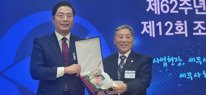 구재이 한국세무사회장이 ‘50년 세무사상’을 수상한 이종성<오른쪽> 세무사와 기념 촬영을 하고 있다.
