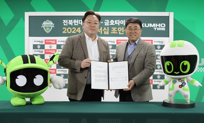 금호타이어 G.마케팅담당 윤장혁 상무<오른쪽>와 전북현대모터스 이도현 단장이 공식 파트너십 조인식을 갖고 사진 촬영을 하고 있다.