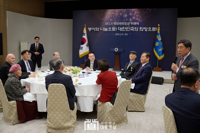 윤석열 대통령이 15일 용산 대통령실 자유홀에서 열린 제13기 국민추천포상 수여식에 참석해 4천600명의 학생에게 32억원의 장학금을 후원해 온 조용근 세무법인 석성 회장의 발언을 듣고 있다.(사진 출처=대통령실 홈페이지)
