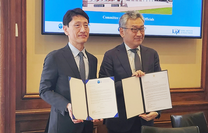 김윤상<왼쪽> 기획재정부 차관이 18일(현지시간) 한-OECD 국제공동연구 착수식에 참석, 요시키 다케우치 OECD 사무차장과 의향서에 서명 후 기념촬영을 하고 있다<사진=기재부>.