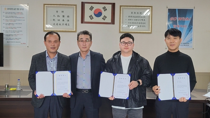 김덕호 광주종합주류도매업협회장<왼쪽 두 번째>이 임직원 자녀에 입학 축하 장학금을 수여하고 있다. 