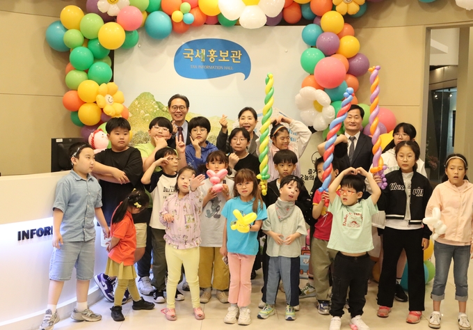 서울청 '신나는 세금교실'에 참여한 서울농학교 학생들과 김은숙 교장, 강민수 서울청장이 국세홍보관에서 사진을 찍고 있다. 
