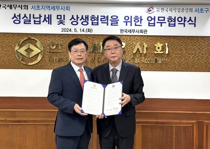 신기탁<왼쪽> 서초지역세무사회장과 박창훈 한국외식업중앙회 서초구지회장이 업무협약을 체결하고 있다. 