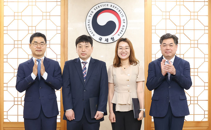 김창기<왼쪽> 국세청장과 김태호<오른쪽> 차장이 'AI상담사'를 개발한 김경민<왼쪽 두번째>·이영신 조사관에게 특별승진 임명장을 수여 후 기념촬영하고 있다. 