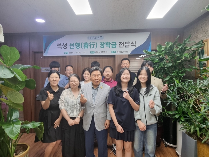 조용근 석성장학회 이사장(앞줄 가운데)이 천안함 생존장병 자녀와 전사자 유자녀들에게 장학금을 전달하고 있다.