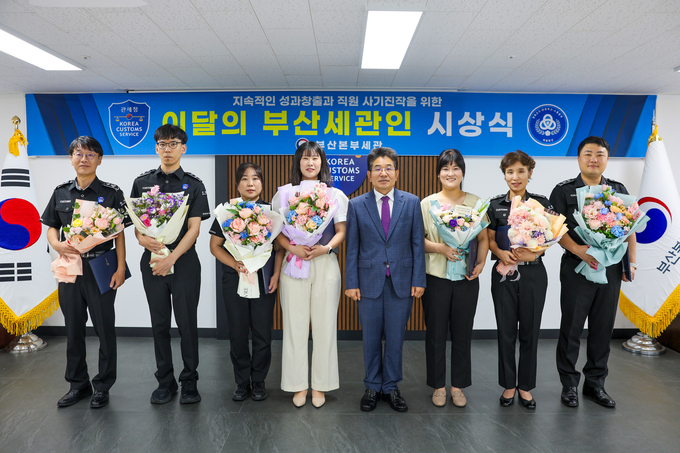 김용식 부산세관장(왼쪽 다섯번째)이 8월의 부산세관인에 선정된 최신옥 주무관(왼쪽 네번째) 및 유공자들과 기념촬영을 하고 있다.
