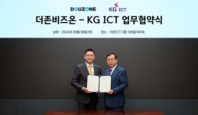 이강수 더존비즈온 사장(오른쪽)과 이상준 KG ICT 대표가 협약서를 교환하고 있다.