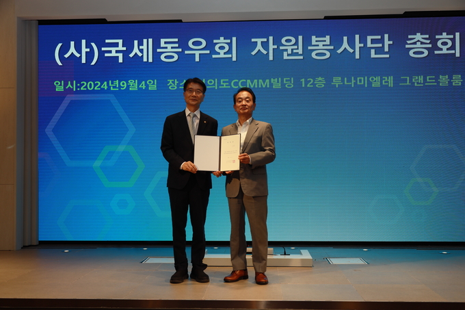 전형수 국세동우회장이 새롭게 지명된 임채수<왼쪽> 문우회장에게 위촉장을 전달하고 있다. 