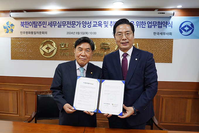구재이 한국세무사회장과 조용근 민주평통 북한이탈주민지원특별위원장이 업무협약을 체결하고 있다. 