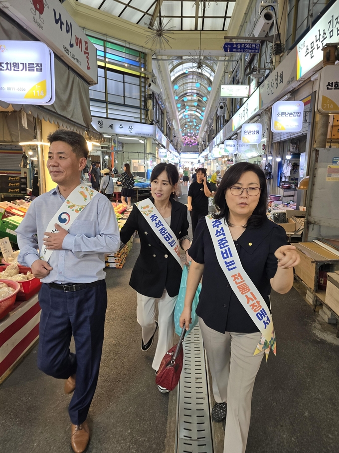 이순우 서대전지역세무사회장과 김한수 세무사, 김은수 대전지방세무사회 사무국장이 '추석준비는 전통시장에서' 어깨띠를 두르고 장보기를 하고 있다.