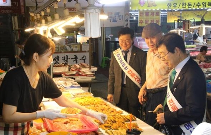 이중건 중부지방세무사회장(오른쪽 첫번째)이 지난 12일 안양중앙시장에서 전을 구매하고 있다. 
