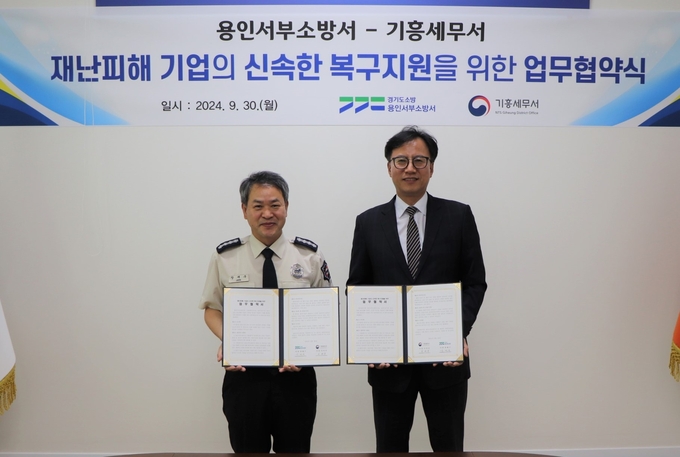 이미진 기흥세무서장<오른쪽>과 장재구 용인서부소방서장이 30일 재난피해 기업의 신속한 복구지원을 위한 업무협약을 체결하고 있다.