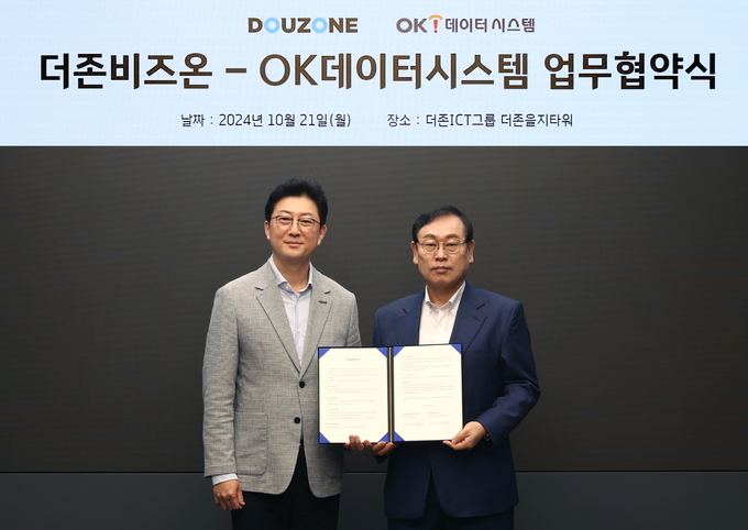 이강수 더존비즈온 ERP사업부문대표 사장(오른쪽)과 최상웅 OK데이터시스템 대표가 옴니이솔의 전 산업계 확산을 위한 파트너십 업무협약을 체결하고 기념촬영을 하고 있다.