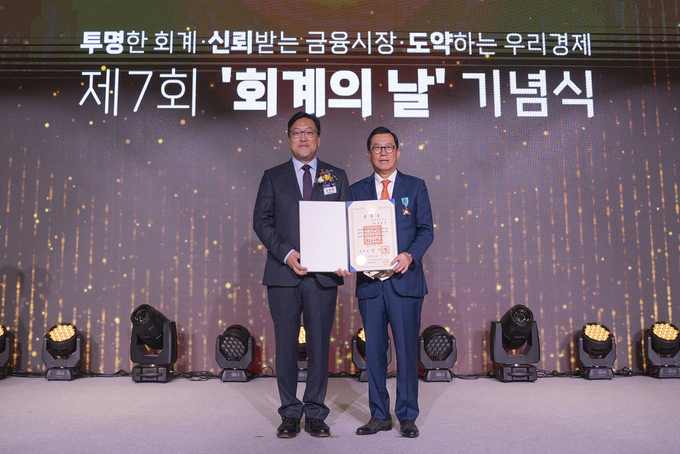 김영식 전 삼일회계법인 대표이사(오른쪽)가 '제7회 회계의 날' 행사에서 철탑산업훈장을 수상한 후 김병환 금융위원장과 사진 촬영을 하고 있다. 
