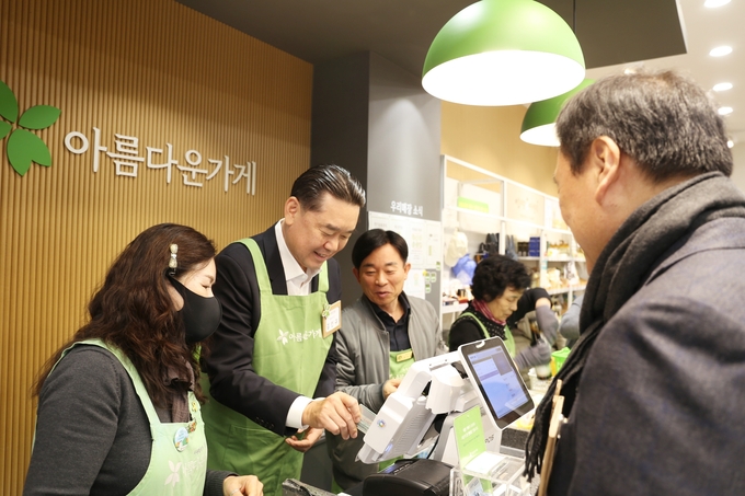 김인규 하이트진로 대표이사가 지난 19일 아름다운가게 분당이매점에서 진행된 제13회 아름다운하루 특별전에서 판매 봉사활동을 하고 있다.