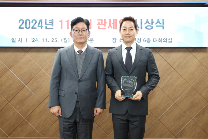 고광효 관세청장<왼쪽>이 11월의 관세인에 선정된 인천공항세관 유영환 주무관과 기념 촬영하고 있다.