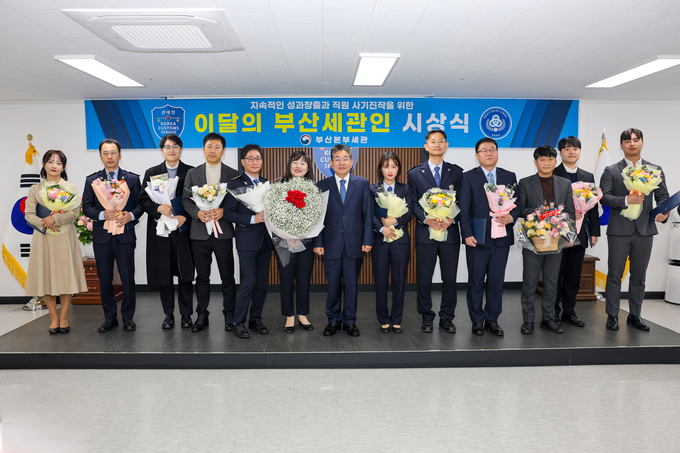 김용식 부산세관장(가운데)은 ‘올해의 부산세관인’에 선정된 이재란 주무관(왼쪽 여섯번째), 올해의 업무분야별 유공자과 기념촬영하고 있다.