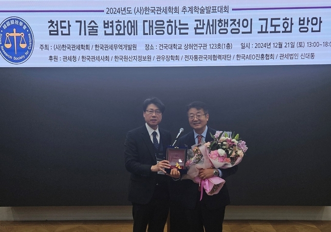 신민호 서울지방관세사회장<오른쪽>이 송선욱 한국관세학회장으로부터 2024년 관세진흥대상을 수상하고 있다.