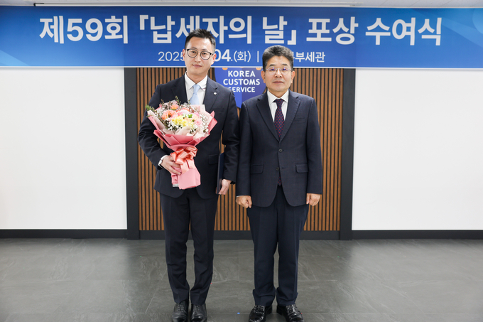 김용식 부산세관장(오른쪽)이 기획재정부장관 표창을 수상한 (주)디더블유엘 글로벌 최진용 팀장과 기념촬영하고 있다.