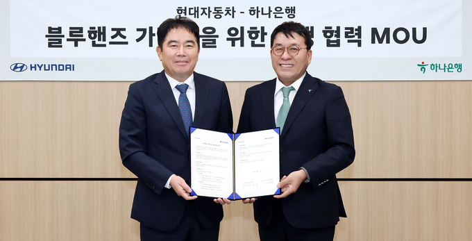 김진우 하나은행 중앙영업그룹 부행장(오른쪽)이 지난달 30일 블루핸즈 가맹점 금융지원을 위한 업무협약 체결 후 기념촬영을 하고 있다. (사진=하나은행)