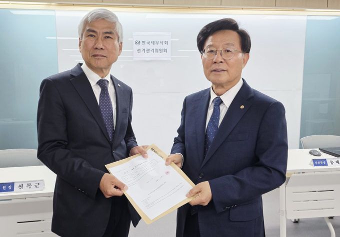 구광회(오른쪽) 한국세무사회 감사 후보가 신목근 선관위원장에 예비후보등록 서류를 제출하고 있다. 