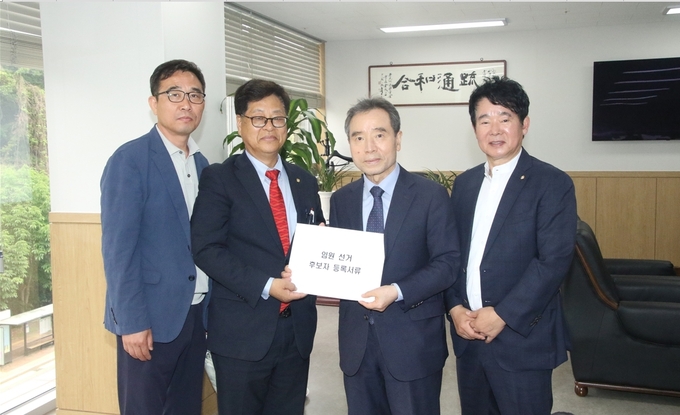 이재실<왼쪽 두번째> 중부지방세무사회장 후보가 김대건<맨오른쪽>·한승일<맨왼쪽> 부회장후보와 함께 박흥로 선관위원장에게 등록서류를 제출하고 있다.