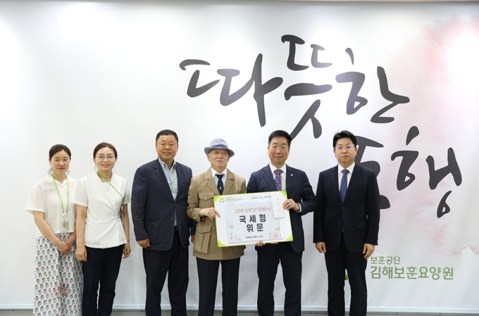 이동운<오른쪽 두번째> 부산청장이 김해보훈요양원 측에 위문금을 전달하고 있다. 