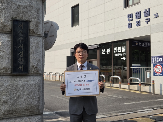 한국세무사회 김선명 부회장이 수서경찰서 앞에서 고발장을 들고 있다<사진=세무사회>. 