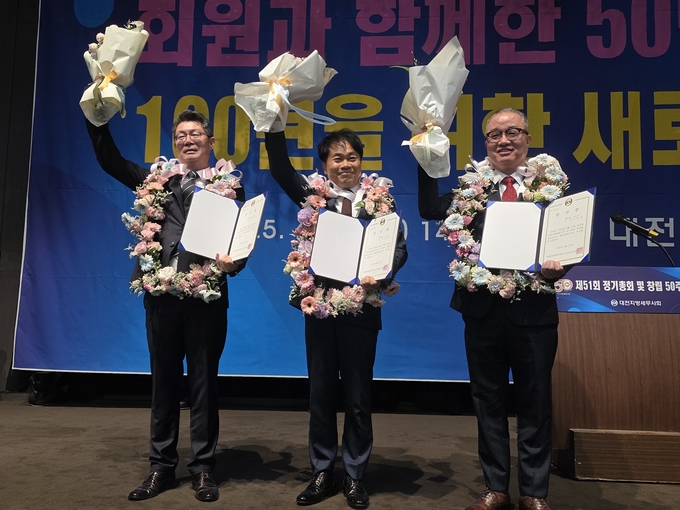 신용일 신임 회장(가운데)이 김정덕 부회장(왼쪽), 안봉훈 부회장(오른쪽)과 꽃다발을 들고 기뻐하고 있다. 