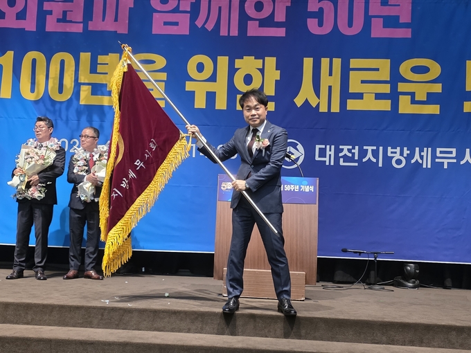 신용일 회장이 대전지방회 회기를 흔들고 있다. 
