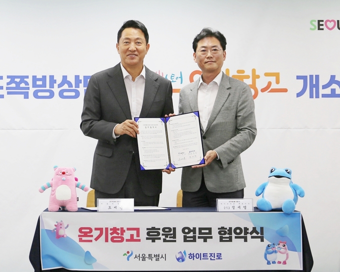 정세영 하이트진로 상무(오른쪽)가 오세훈 서울시장과 23일 서울특별시립 영등포쪽방상담소에서 ‘서울시 5대 쪽방촌 온기창고 정기 후원 업무협약’을 체결했다.
