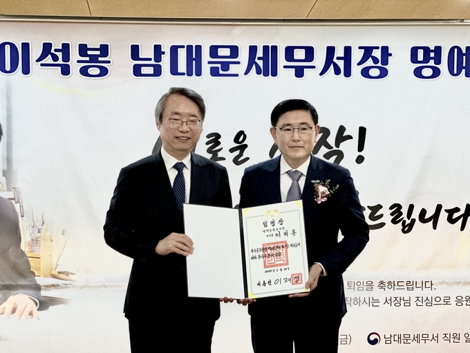이석봉 남대문세무서장이 김오영 서울청 송무국장으로부터 부이사관 승진 임명장을 받고 있다. 