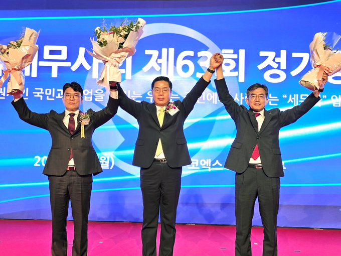 연임에 성공한 구재이<가운데> 한국세무사회장과 최시헌<오른쪽>·김선명 부회장이 회원들에게 인사하고 있다. 