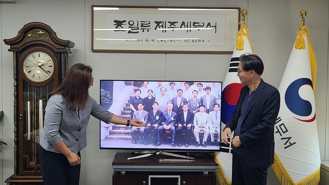 강민수 국세청장이 2016년 제주세무서 근무 당시 촬영했던 기념사진 영상을 함께 근무했던 최희경 조사과장이 설명하고 있다.<영상 속 앞줄 왼쪽 첫번째 전임 김창기 국세청장, 그 옆이 강민수 국세청장> 
