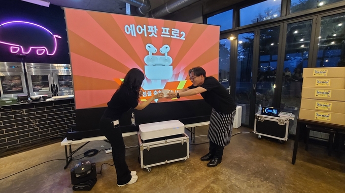 앞치마를 두른 강민수 국세청장이 만찬 이후 이어진 경품행사에서 교육생들에게 선물을 증정하고 있다. 